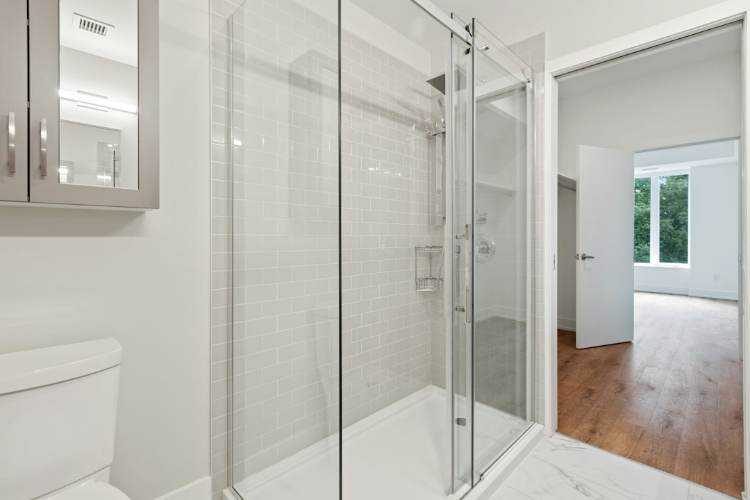 Glass shower doors in a tiled bathroom