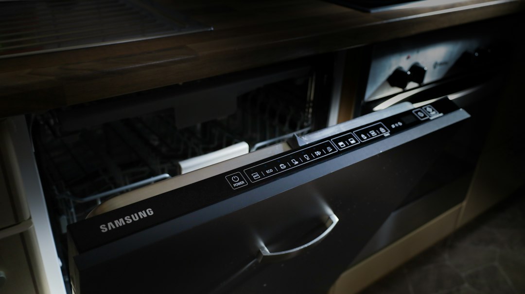 Partly open Samsung dishwasher showing its door controls