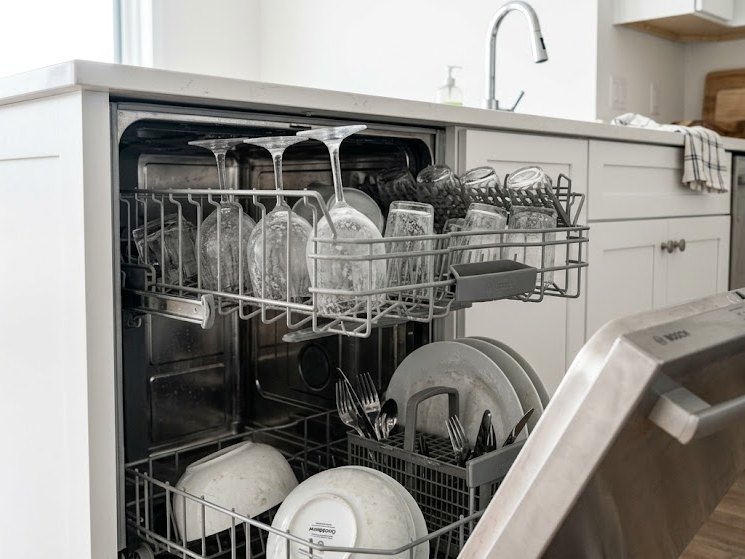 Dishwasher leaves white residue on dishes caused by hard water mineral buildup.