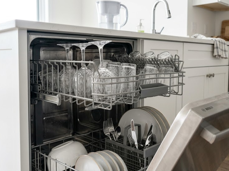 Dishwasher leaves white residue on dishes caused by hard water mineral buildup.