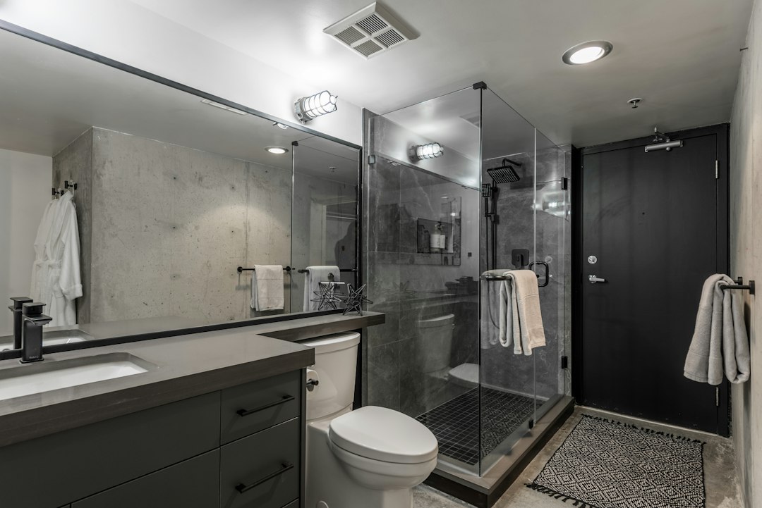 Bathroom showing shower glass, tile, and fixtures