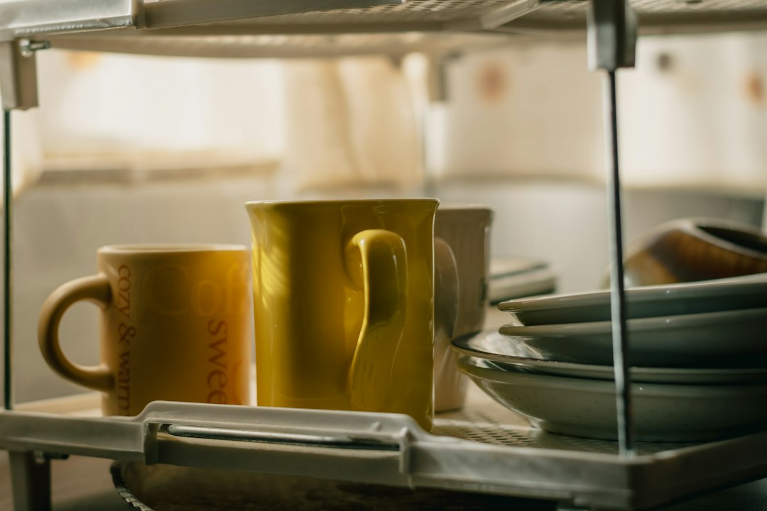Cups and dishes beside a kitchen sink